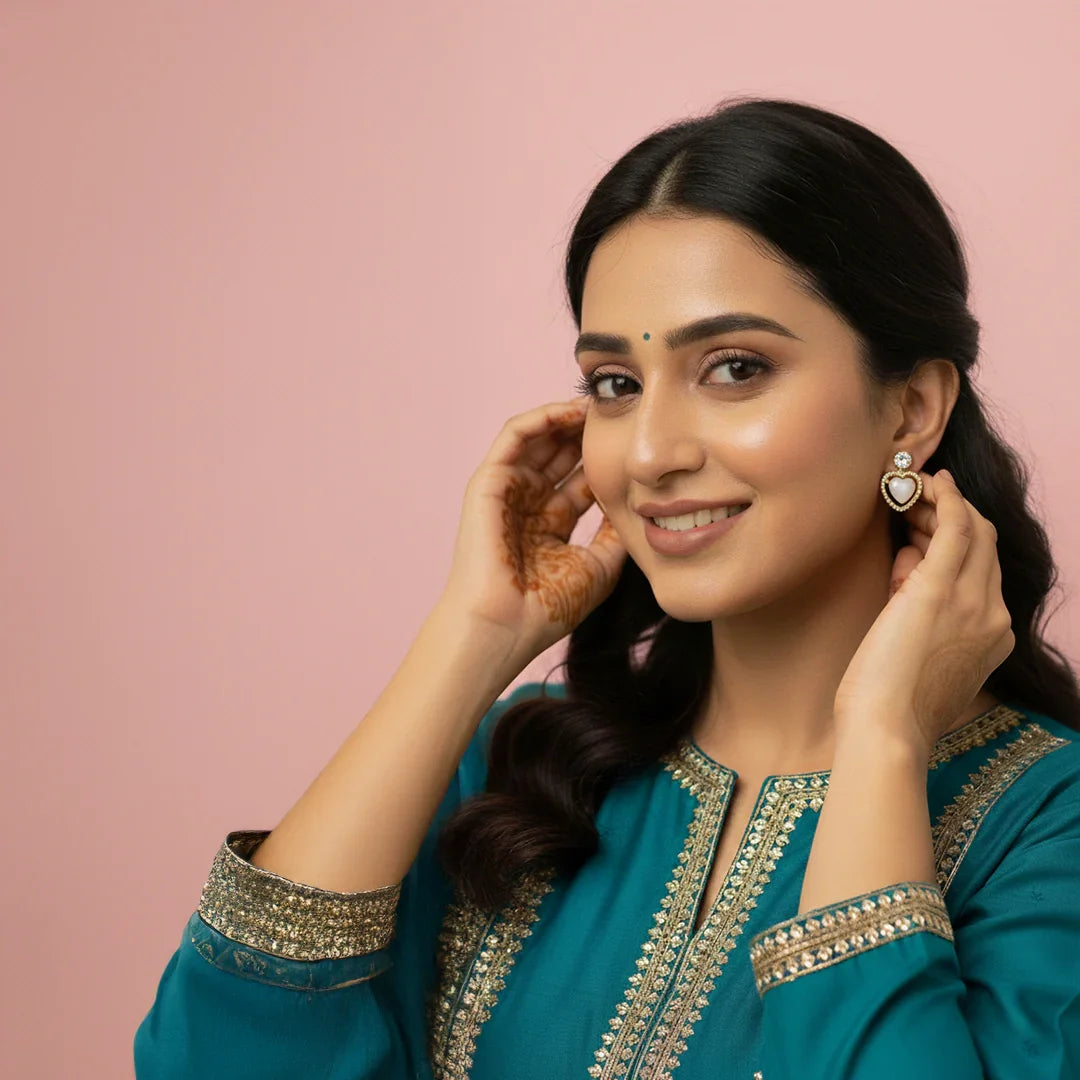 Clooz Woman wearing a teal traditional outfit with gold embroidery against a pink background