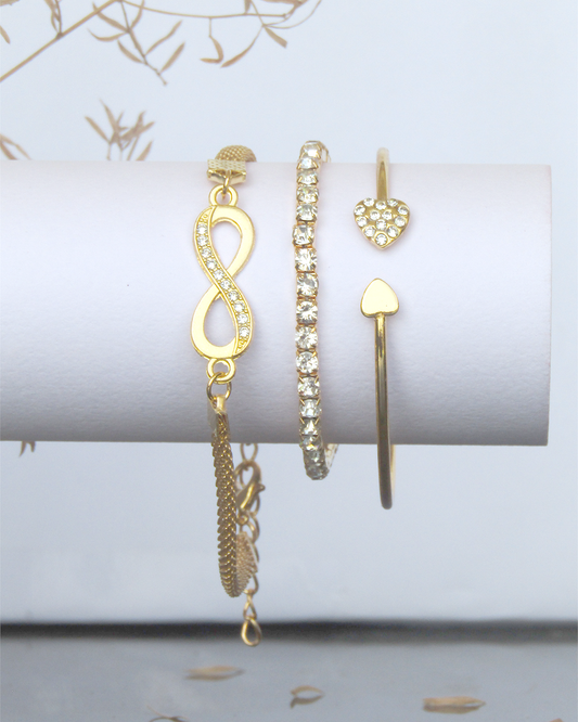 Set of gold Plated jewelry including earrings and bracelets on a white surface with a light background.